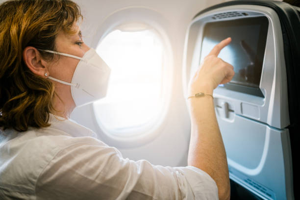 istock traveller woman wearing face mask while sitting on airplane 1410518115