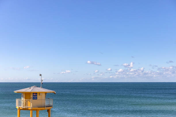 Surf life patrol tower against ocean water, background with copy space, full frame horizontal composition