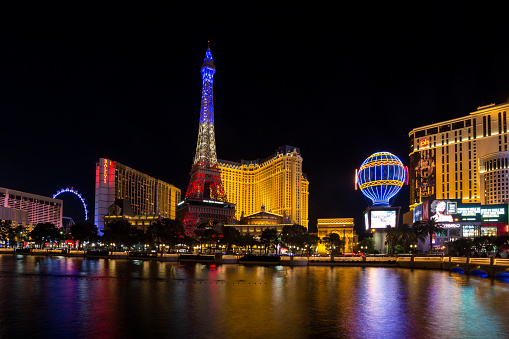 Las Vegas, Nevada - July 5th, 2022: Eiffel Tower replica and Paris hotel and casino on The Strip viewing from Bellagio illuminated by neon lights