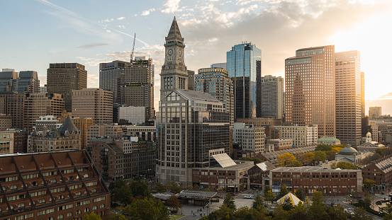 Boston city skyscrapers with historic Custom House Clock Tower at the backdrop and Faneuil Hall Marketplace at the front.