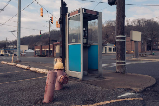 vintage telephone booth on street corner of downtrodden small midwestern town - coin operated pay phone telephone communication imagens e fotografias de stock