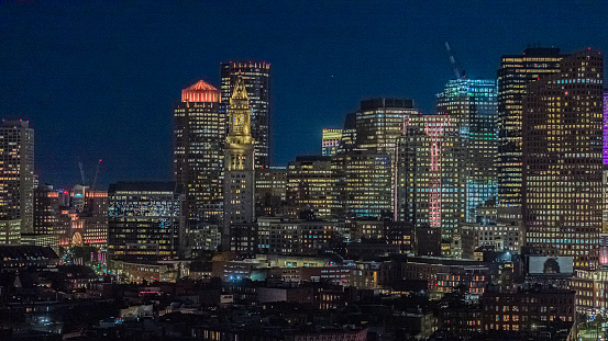 Night illumination of Harbor Towers, Custom House Clock Tower in Downtown Boston, MA.