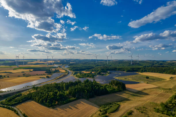 istock solar farm and wind turbines near the highway road interchange (aerial) 1410527800