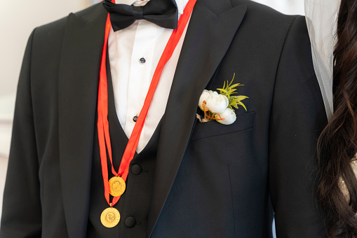 gold jewelry for groom. \nbow tie and gold jewelery close-up. Shot with a full frame camera.
