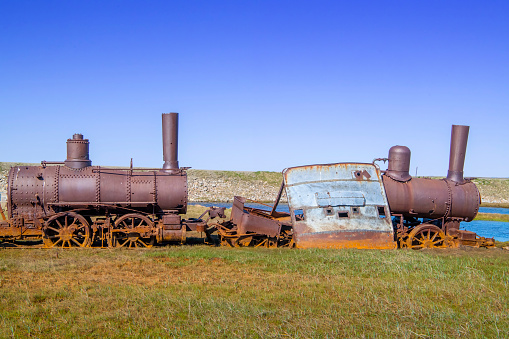 Rusting parts of the “The Last Train to Nowhere” on the Arctic tundra near Safety Sound south of Nome, Alaska. The steamship Aztec delivered three locomotives, track, and railroad ties to the site in 1903, and the Council City & Solomon River railroad was born.  Construction stopped in 1906 after 35 miles of track were laid and the gold ore ran out. The old locomotives and scattered derelict parts are all that remain.