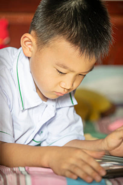 istock Children crawling on the bed playing with cell phones 1410533486
