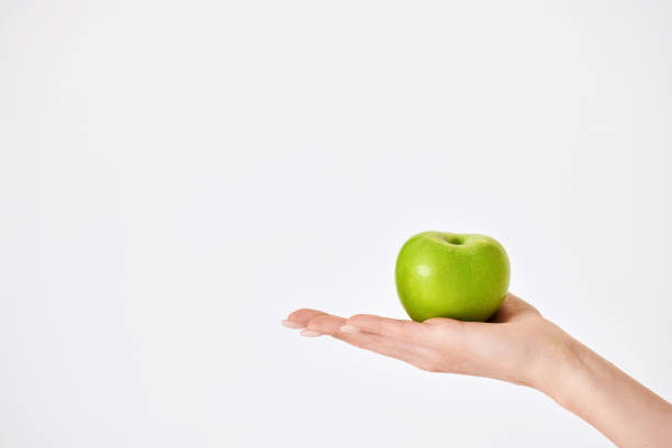 istock female hand holding red apple on white background 1410536494