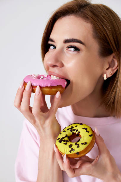 istock beautiful blonde woman with donuts on white background. 1410536527