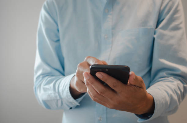 istock close up man hand holding mobile smartphone copy space.person texting text message internet technology concept. 1410536568