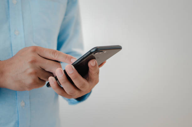 istock close up man hand holding mobile smartphone copy space.person texting text message internet technology concept. 1410536583