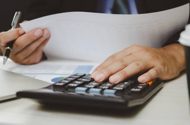 istock businessman holding calculators and business documents charts statistical data investment analysis and tax accounting. 1410536605