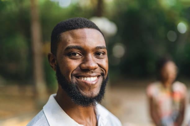 istock Smiling young man in public park 1410538852