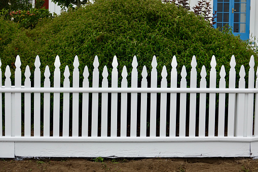 A white fence by a green grass field