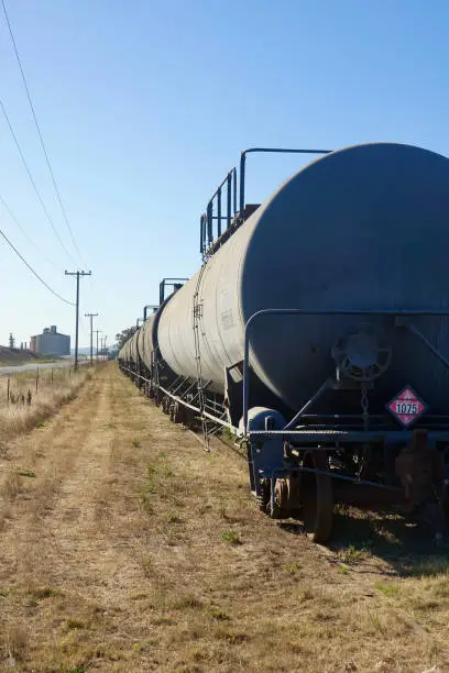 Long view of row of oil tankers on the train tracks