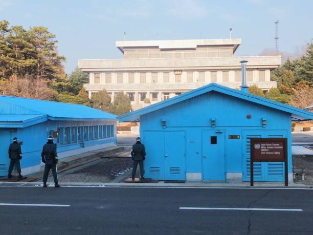 Panmunjom, North Korea – November 30, 2013: A South Korean soldier stands guard on the exact border between North and South Korea. The two countries have been at war since 1950. The border between them - known as the Demilitarized Zone, DMZ, or Joint Security Area, JSA - is the most heavily guarded border in the world. Here, in the Blue House, officials from North and South Korea can meet without officially leaving their countries.