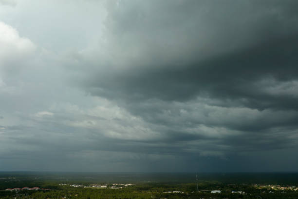 dark stormy clouds forming on gloomy sky before heavy rainfall over suburban town area - florida weather urban scene dramatic sky imagens e fotografias de stock