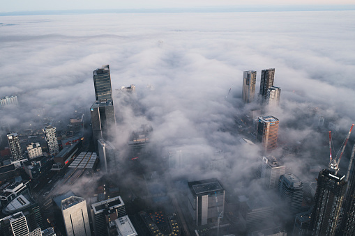 Aerial view of a downtown central business district with fog and mist amongst buildings in the morning sun