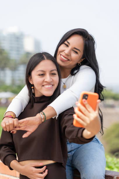istock Lesbian couple embracing while taking selfie outdoors 1410556207