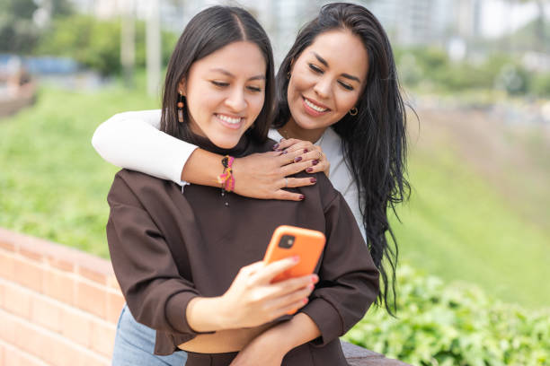 istock Lesbian women embracing while taking selfie outdoors 1410556209