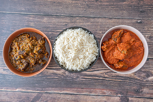 Bowl of rice served with Ofada and Pepper tomato sauce