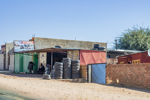 People and a commercial sign visible outside Auto Repair Shop at Katutura Township near Windhoek at Khomas Region, Namibia