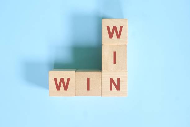 Win-win or win win in business concept. Wooden block crossword puzzle  flat lay in blue background. Win-win or win win in business concept. Wooden block crossword puzzle  flat lay in blue background. co dependent relationship stock pictures, royalty-free photos & images