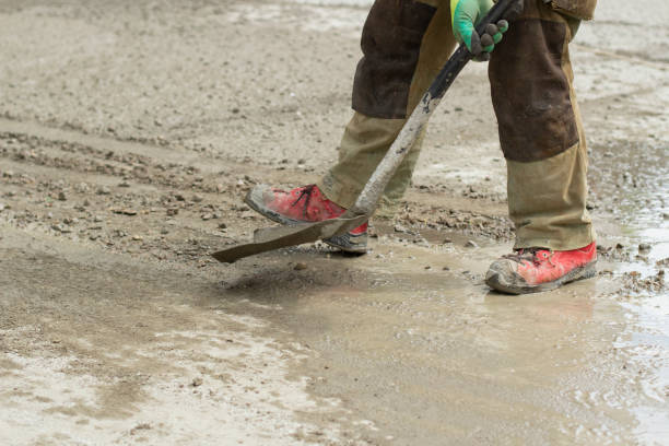 istock Work with a shovel at a construction site. A worker throws cement and gravel with a shovel. 1410586195