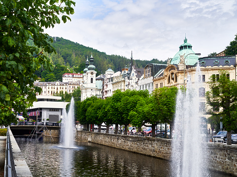 Eger River constricted in walls with fountains in riverbed flowing through historical center with neo-baroque facades in Karlovy Vary, Czech Republic