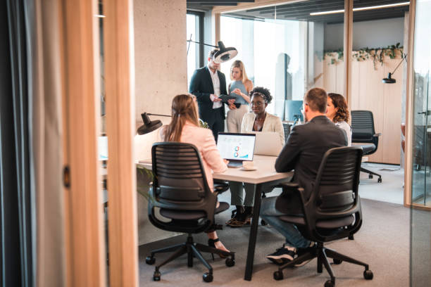 istock Young Multiracial Office Coworkers Sitting Around A Desk And Discussing Ideas At Work 1410588858