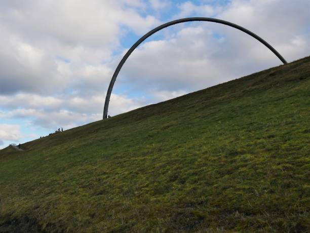 metallic arch formed from pipe of the hoheward halde heap horizon observatory in front of a dramatic cloudy sky - horizon observatory imagens e fotografias de stock