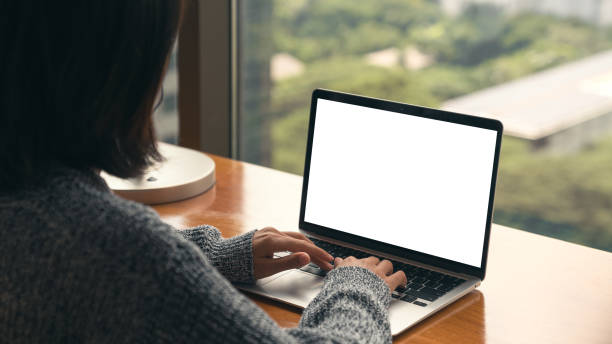 women using laptop showing white screen on desk stock photo