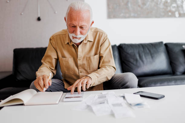 istock Smiling senior man planning home finance 1410595009
