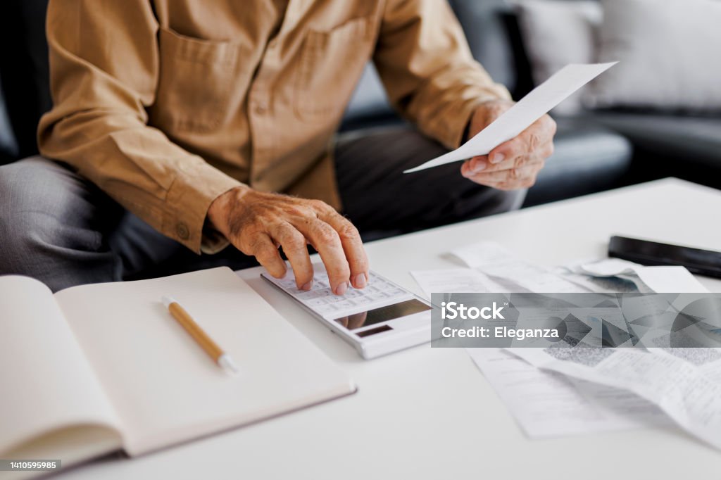 Close up of Senior man checking bills at home Tax Stock Photo
