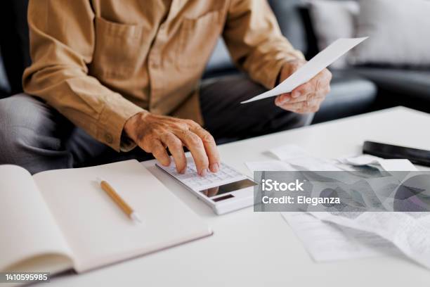 Close Up Of Senior Man Checking Bills At Home Stock Photo - Download Image Now - Tax, Tax Form, Senior Adult