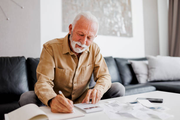 istock Smiling senior man planning home finance 1410597536