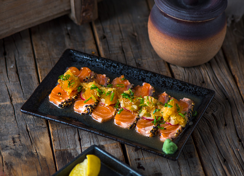 HAMACHI tataki served in a dish isolated on wooden background side view of tataki japanese food