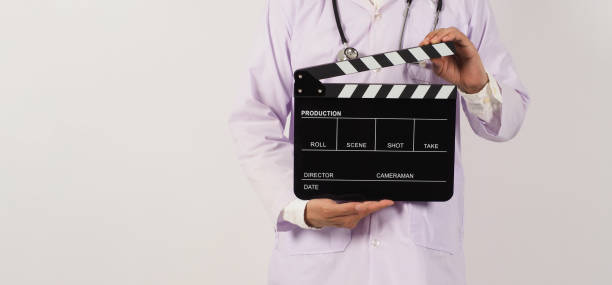 istock Doctor's holding Black Clapper board in hand on white background. Studio shooting. 1410597950