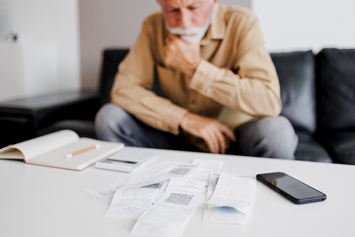 Close up of Angry Senior man checking bills at home