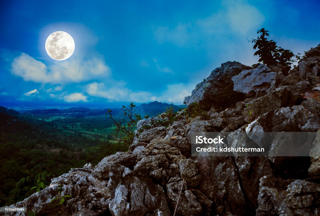 Boulders against sky with beautiful bright full moon above wilderness area in forest. Serenity nature background from national park. Landscape of boulders against sky with clouds over tranquil nature. Beautiful bright full moon above wilderness area in forest. Serenity nature background from national park. Beauty Stock Photo