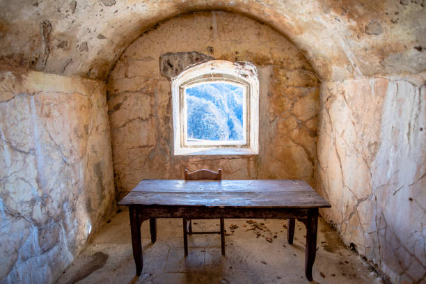 2022 02 26 Pedescala table with chair 1 abandoned room of the first world war with old wooden table and chair with window on the rocks of the alps forte Corbin on the plateau of Asiago Veneto Italy indoors restaurant hotel work tool stock pictures, royalty-free photos & images