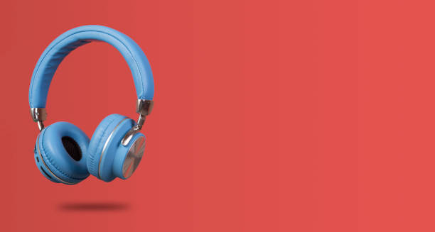 istock Side view of wireless headphone isolated on red banner background 1410602286