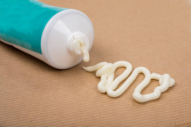 istock Pharmaceutical medicine or healing topical application ointment concept with plastic tube pushing white cream 1410603509