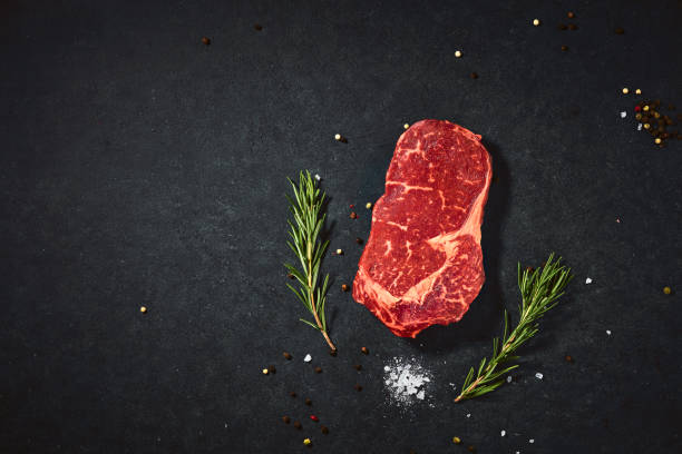 istock Top view fresh red raw meat with spice and salt. Beef steak on a dark table flat lay copy space background 1410605464