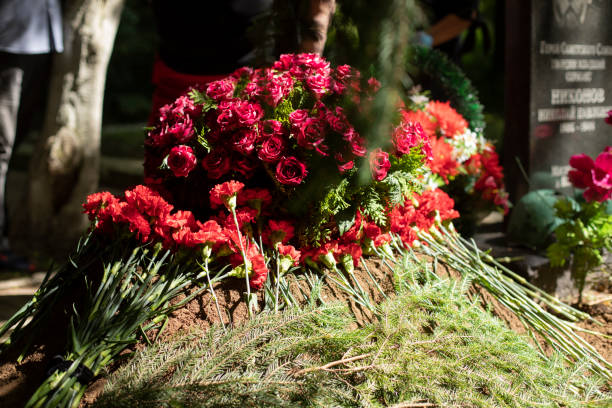 istock Flowers on the grave. Funeral ceremony. 1410605634