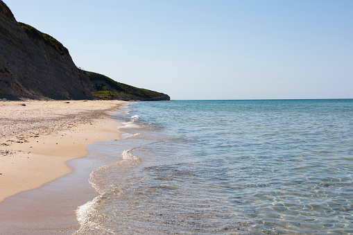 Nice stone beach and turquiose water of cote dAzur at summer morning with open traditional umbrellas, french riviera coast