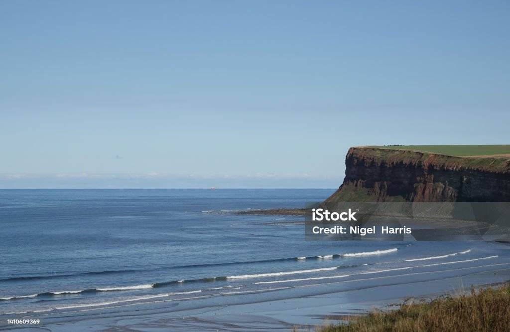 A beautiful view of waves breaking on the North Yorkshire coastline at Saltburn-by-the-Sea. The ocean waves breaking on the shoreline at Saltburn-by-the-Sea, North Yorkshire. Bay of Water Stock Photo