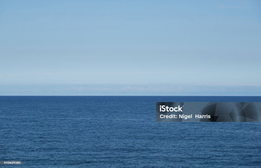 A tranquil view of the calm North sea off the coast of England under a light blue sky. A peaceful view of the calm sea and light blue sky. Backgrounds Stock Photo