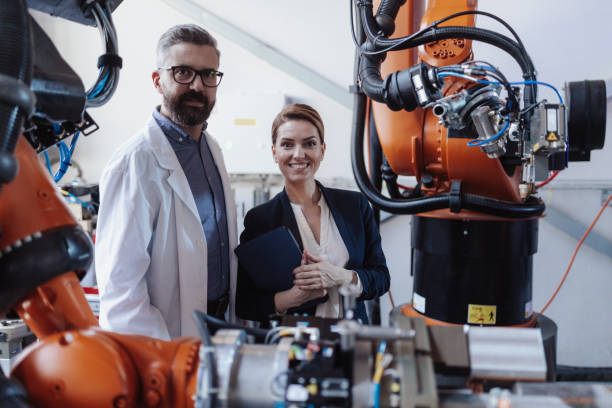 istock Robotics engineers with tablet dicussing and desinging modern robotic arm in factory. 1410610080
