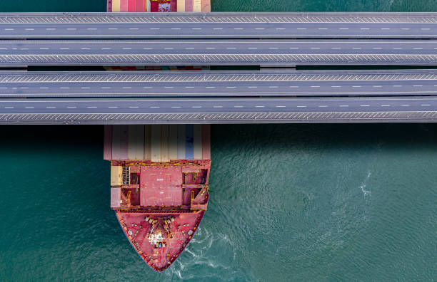 istock Aerial view of a large cargo container ship passing under bridge. 1410610810