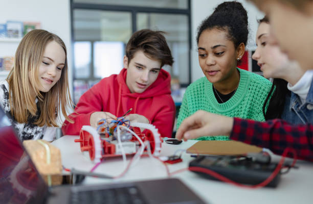 istock Group of high school students building and programming electric toys and robots at robotics classroom 1410611079